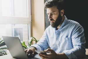Man-analyzing-computer-and-phone