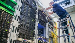 man-installing-network-cabling-in-office-server-room