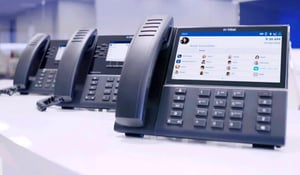 row-of-mitel-phones-on-desk