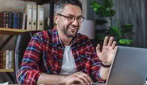 man-waving-at-laptop-on-conference-call